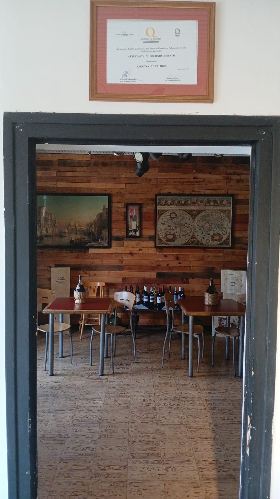 Salón de la vinoteca de Reggina, con vinos y cuadros